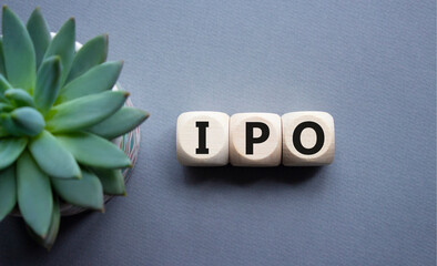 IPO- Initial Public Offering symbol. Concept word IPO on wooden cubes. Beautiful grey background...