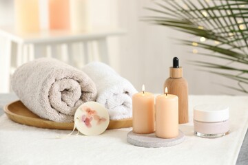 Fototapeta na wymiar Spa composition. Burning candles and personal care products on soft surface