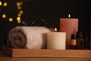 Beautiful composition with different spa products on wooden table against blurred lights