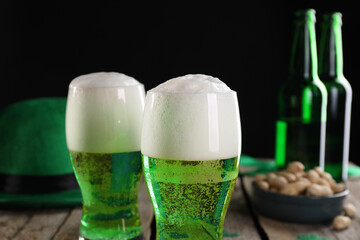 St. Patrick's day party. Green beer, leprechaun hat and nuts on wooden table, closeup