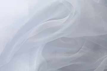 Texture of white tulle fabric as background, top view