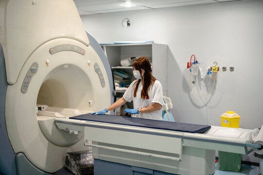 Medical practitioner wiping CT machine table