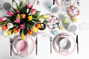 Festive table setting with beautiful flowers, flat lay. Easter celebration