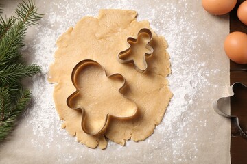 Making Christmas cookies. Raw dough and cutters on table, flat lay