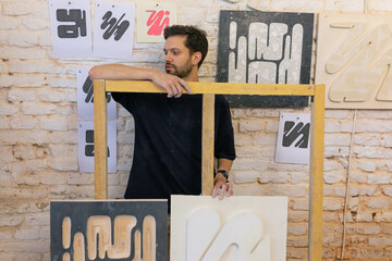 man posing in his paintings