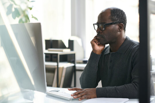 Pensive Black Manager Working On Computer