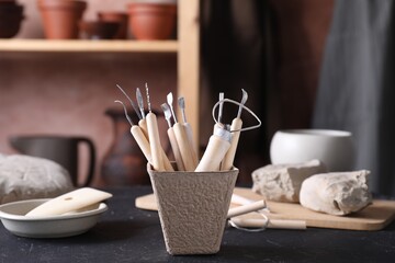 Clay and set of modeling tools on table in workshop