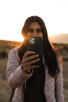 happy brunette woman using her phone