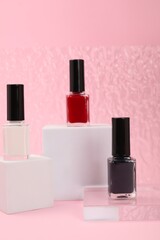 Stylish presentation of nail polishes on pink background