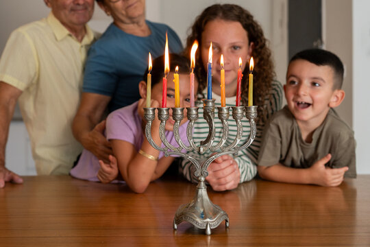 Hanukkah Menorah Shines with Smiling Family.
