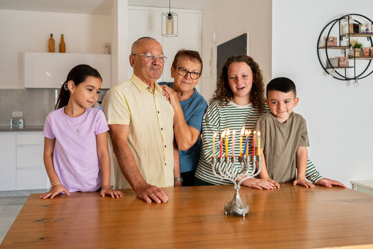 Jewish Family Admire Lit Hanukkah Candles, Singing Joyfully.