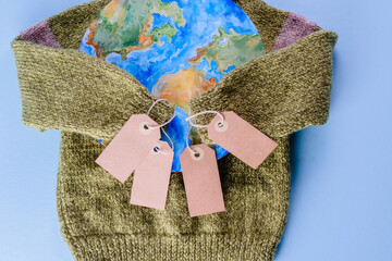 Creative concept buy less and overconsumption. The sweater sleeves holding the tags in the embrace...