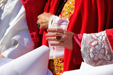 Bishop in resplendent red vestments blesses congregation