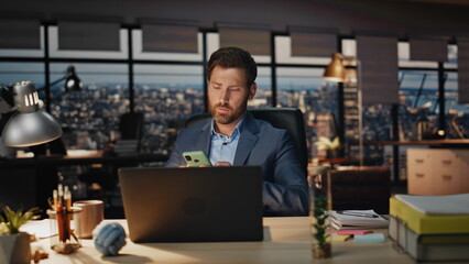 Disappointed manager reading message on smartphone at night office closeup