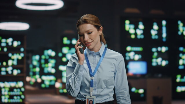 Computer scientist lady answering cellphone call talking at datacenter closeup.