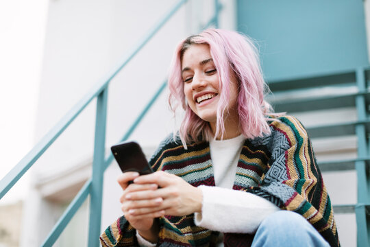 Pink-haired woman using a mobile phone