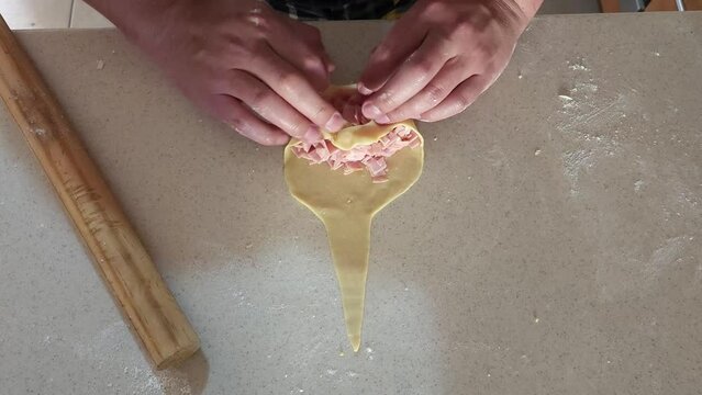 
Process of preparing ham and cheese croissants called "cachitos" in Venezuela