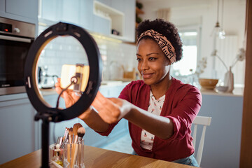 Woman creating a makeup tutorial for her vlog at home