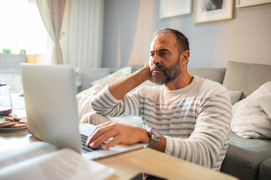 Middle aged Caucasian man using laptop at home