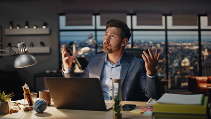 Aggressive guy watching computer at dark room closeup. Angry man gesturing hands