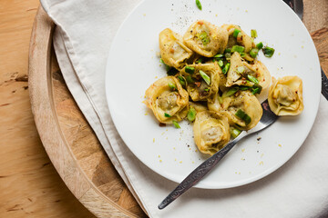 Mushroom tortellini with butter and herbs.