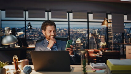 Smiling man reading phone message in evening closeup. Happy director rejoicing