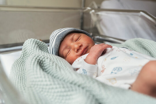 Newborn Sleeping In The Hospital Crib.
