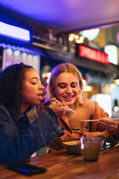 Young women having dinner at a street market