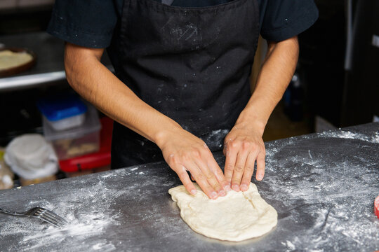 Kneading pizza dough in the kitchen.