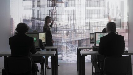 Engineer team in control room. Specialists and team leader having meeting, future construction project data visual graphic on big digital screen.