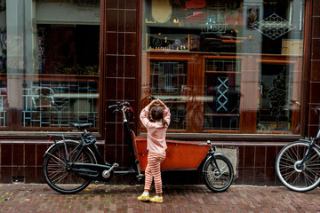 kid posing  by cargo bike