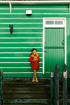 Little  girl against green facade 