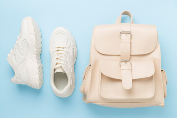 White woman trendy sneakers on color background, top view