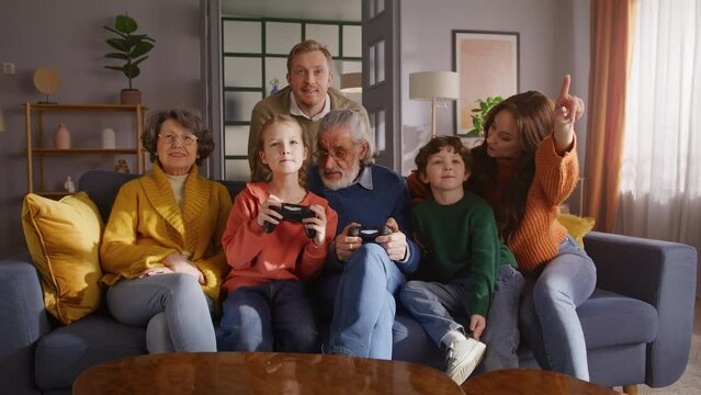Male looking on tv screen while rest of family playing game