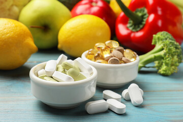 Dietary supplements. Bowls with different pills near food products on light blue wooden table, closeup