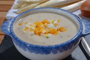 Bowl of homemade cream soup from white asparagus with eggs, spring season, new harvest of Dutch, German white asparagus, cooking with asparagus