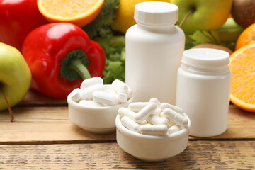 Dietary supplements. Plastic bottles, pills in bowls and food products on wooden table
