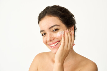 Happy Latin girl, young smiling woman model with freckles applying facial cream isolated on white...