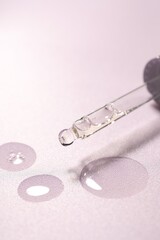 Pipette and moisturizing serum on light violet background, closeup