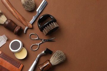 Moustache and beard styling tools on brown background, flat lay. Space for text