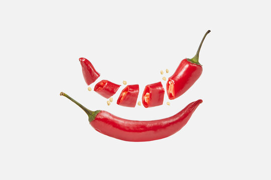 Two cayenne peppers with sliced one over white background