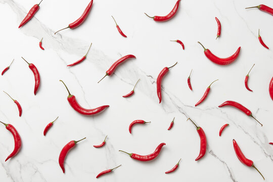 Seamless pattern of fiery chili peppers on marble background