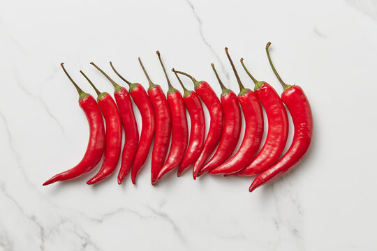 Red chili peppers lying closely on marble background