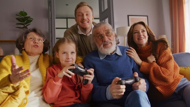 Enthusiastic girl competing with grandfather in video game