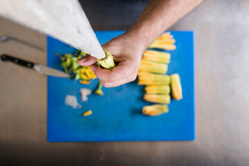 Chef filling zucchini flowers with tasty cream