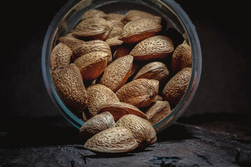 Shelled almonds in a glass jar on rustic wooden table. Macro view