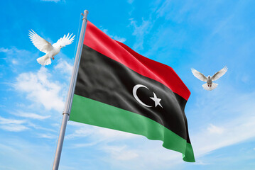 Waving flag of Libya in beautiful sky and flying pigeons. Libya flag for independence day. The symbol of the state on wavy fabric.