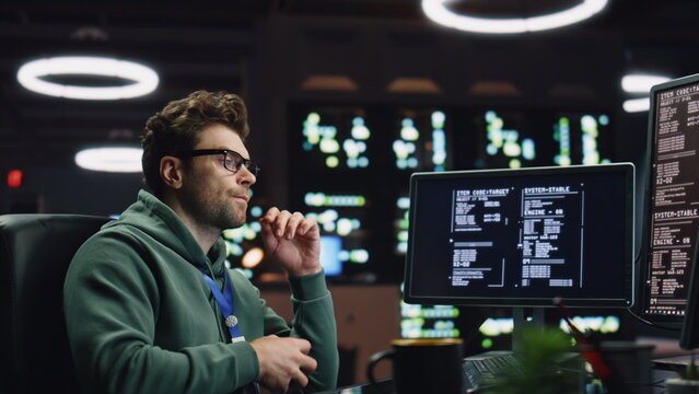 Pondering software developer working computer at server room closeup. IT worker
