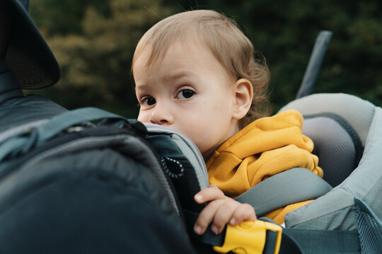 Traveling Father With Child In Baby Carrier