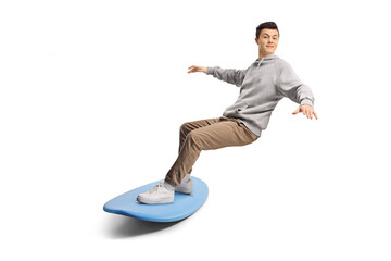 Male teenager surfing with clothes on